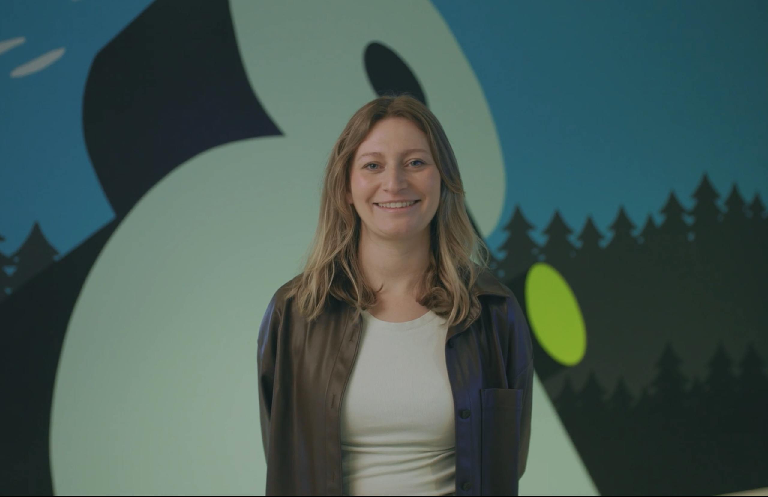 Jenny Cook standing in front of an Amperity office logo mural