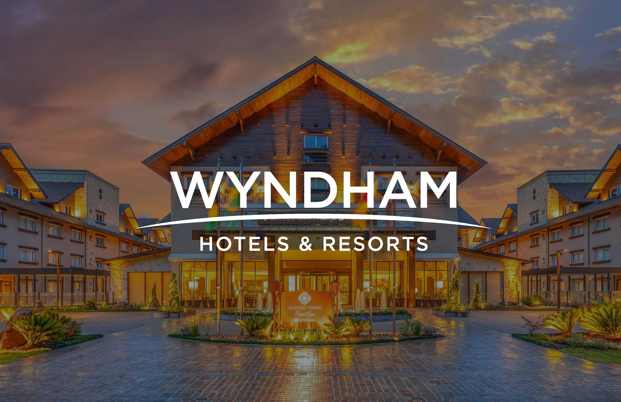 Wyndham Hotels logo overlaid on a photograph of one of their properties at sunset