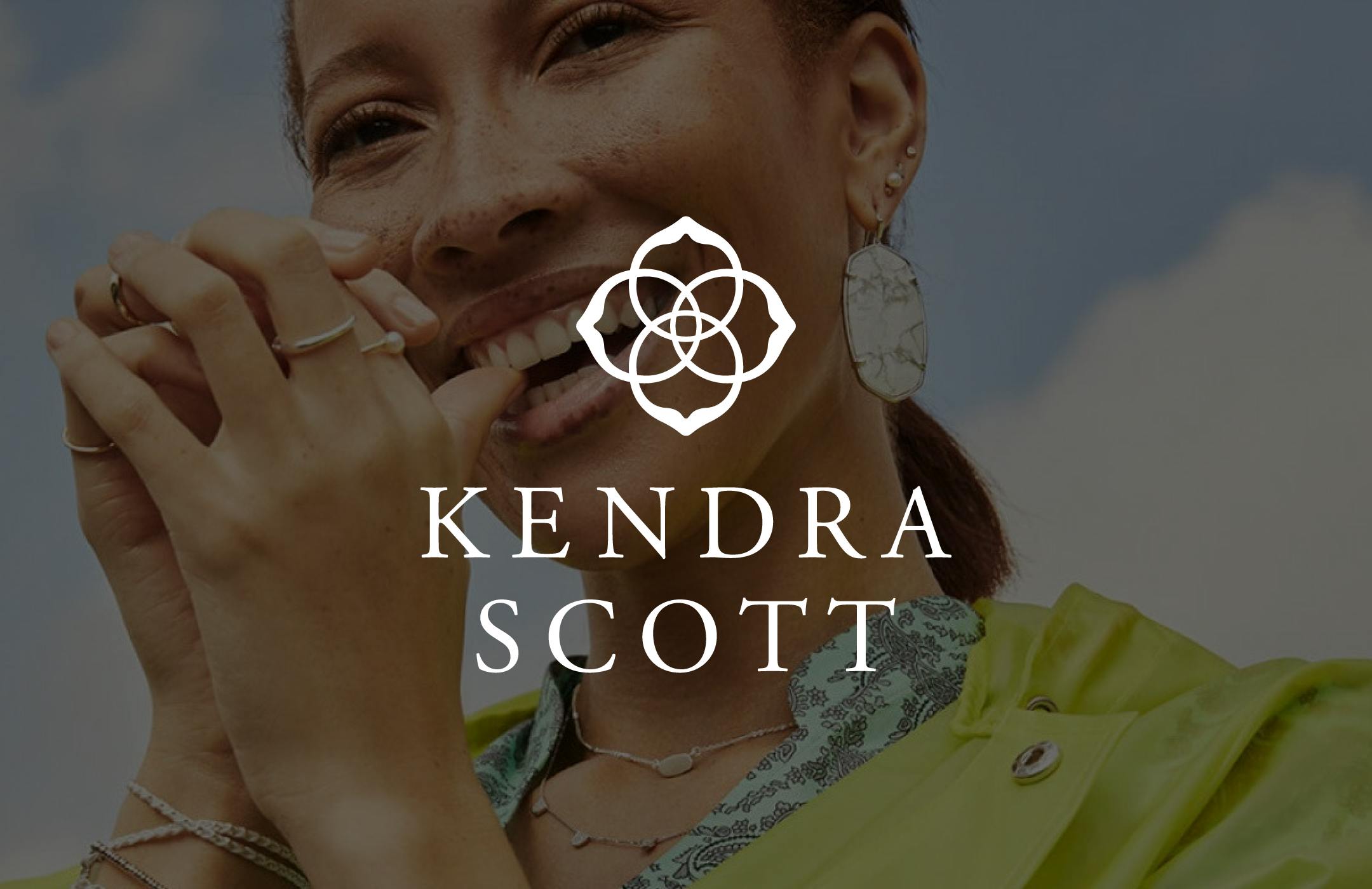 Kendra Scott logo overlaid an image of a woman wearing jewelry