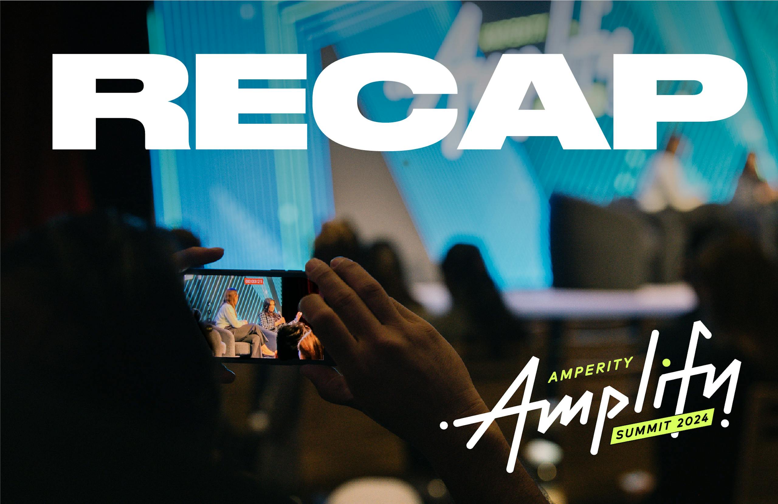 The stage at Amplify, Amperity's annual summit. In the foreground, someone in the audience is taking a photograph or video of what's happening on stage, because they are so engaged.