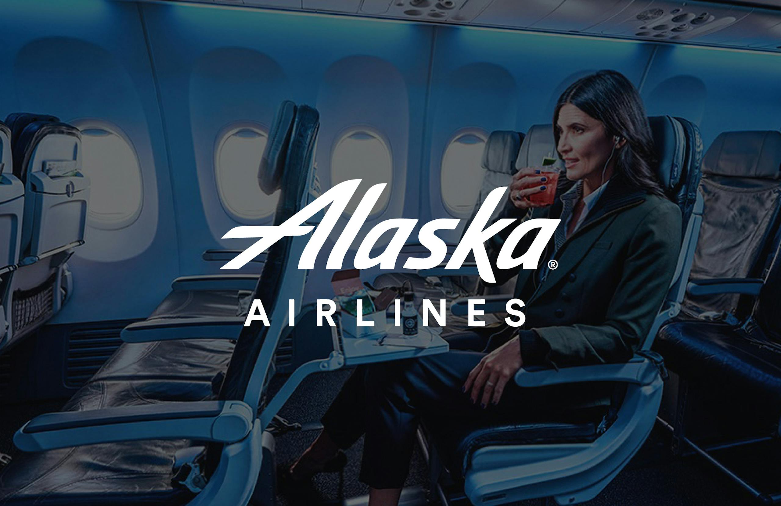 image of Alaska Airlines logo overlaid on a photograph of their first class cabin with people