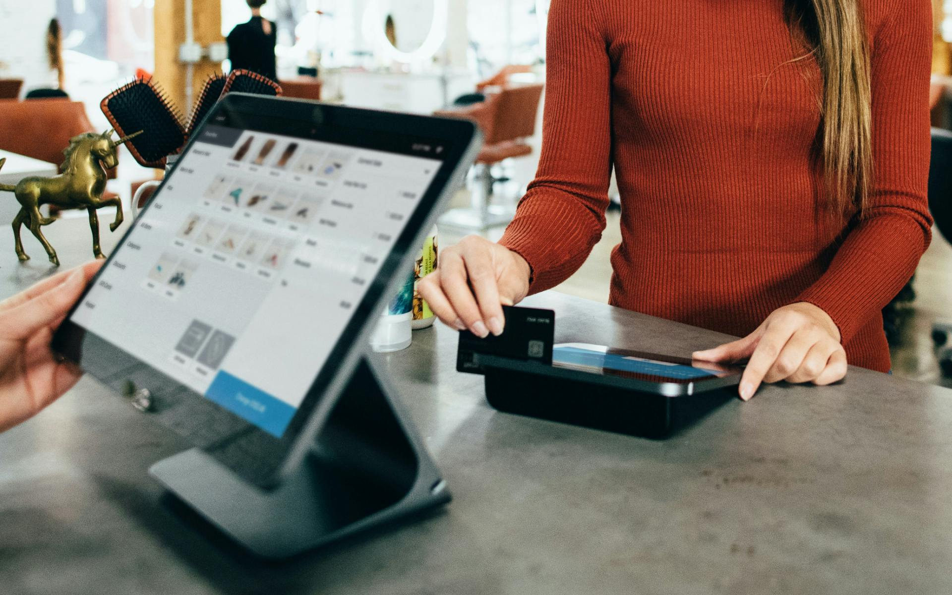 Photograph of a POS System with a customer swiping their credit card