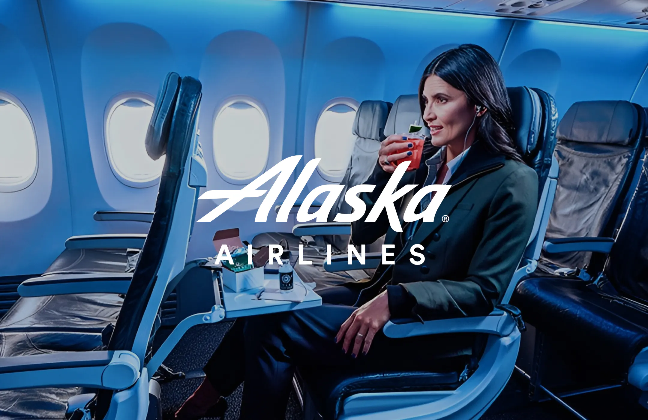 Woman sips a cocktail in her airplane seat