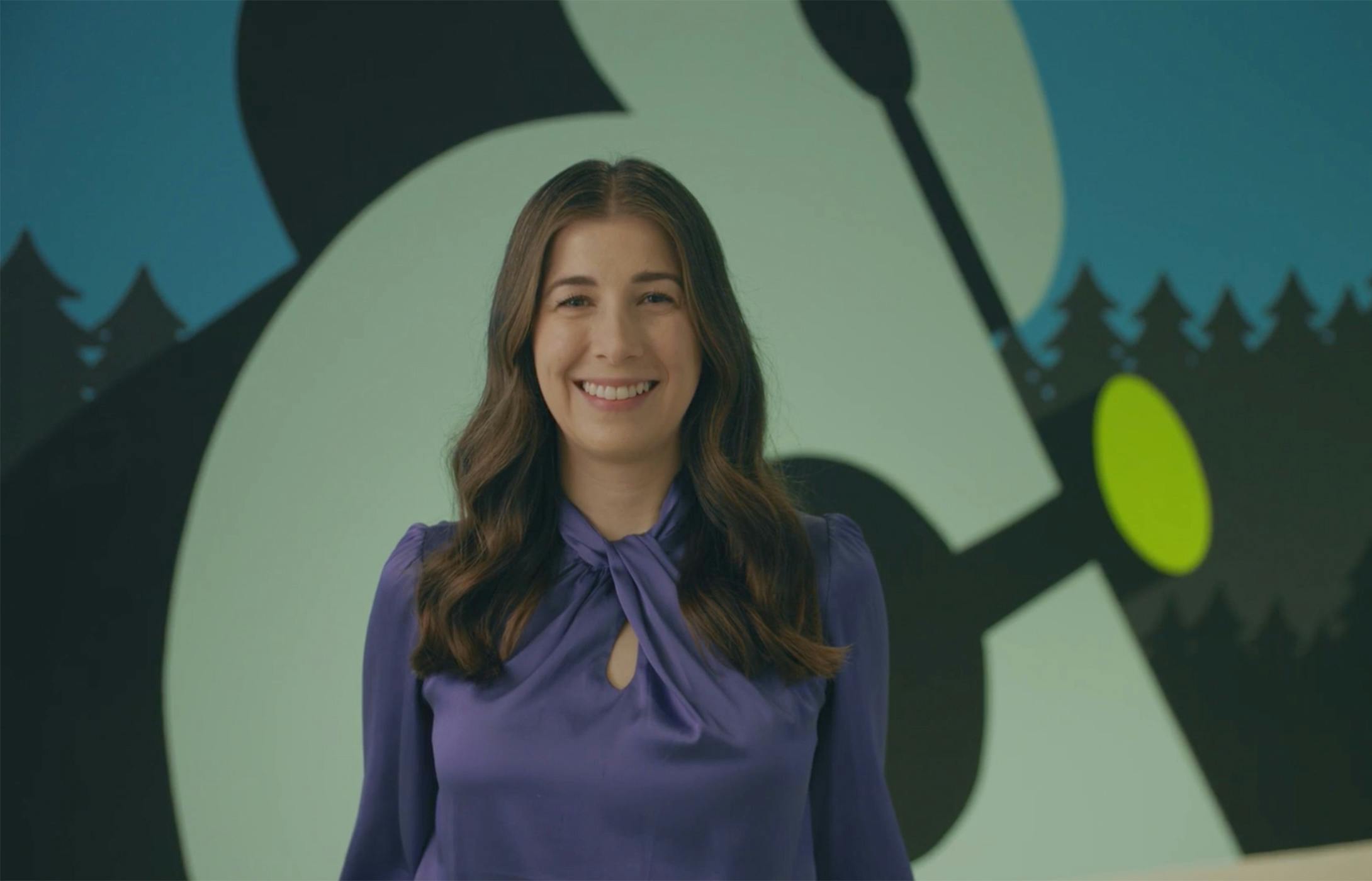 Grace Metzger standing against an Amperity logo mural